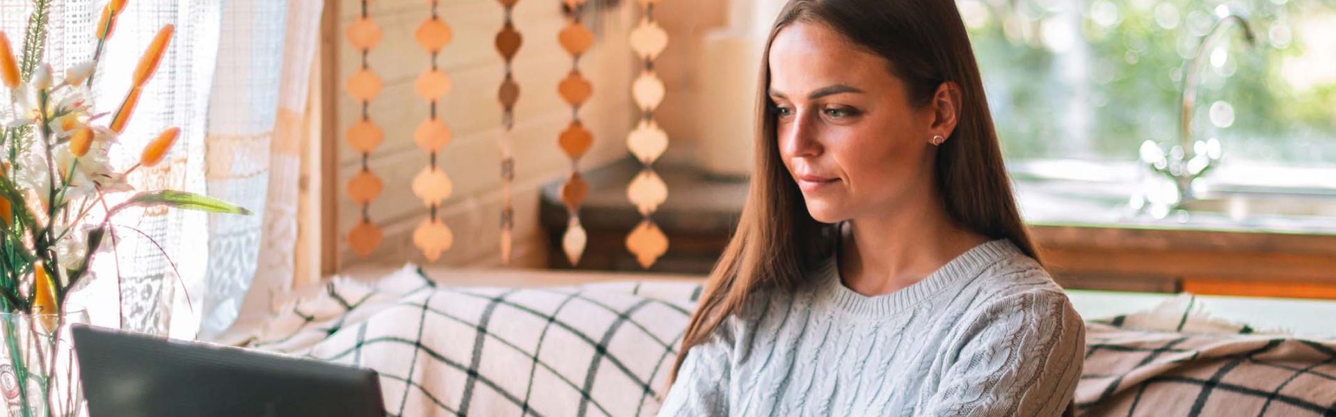 Une femme travaillant chez elle sur un ordinateur